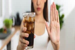 Woman choosing to avoid soft drinks and junk food to protect her dental health and maintain strong, healthy teeth